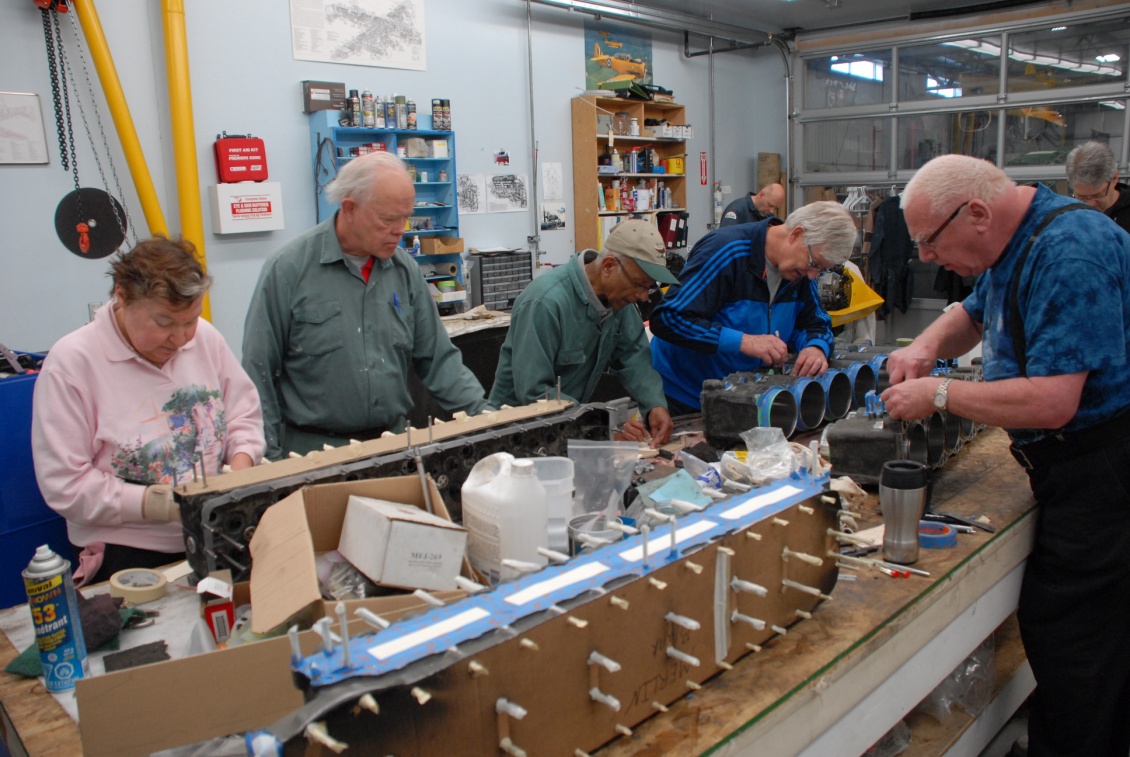 CMS volunteers, Bev, Bert, Roberto, Andy, Cam, Paul and Brian mask and tape the Hurricane Merlin 29 heads and banks in preparation for priming and painting.