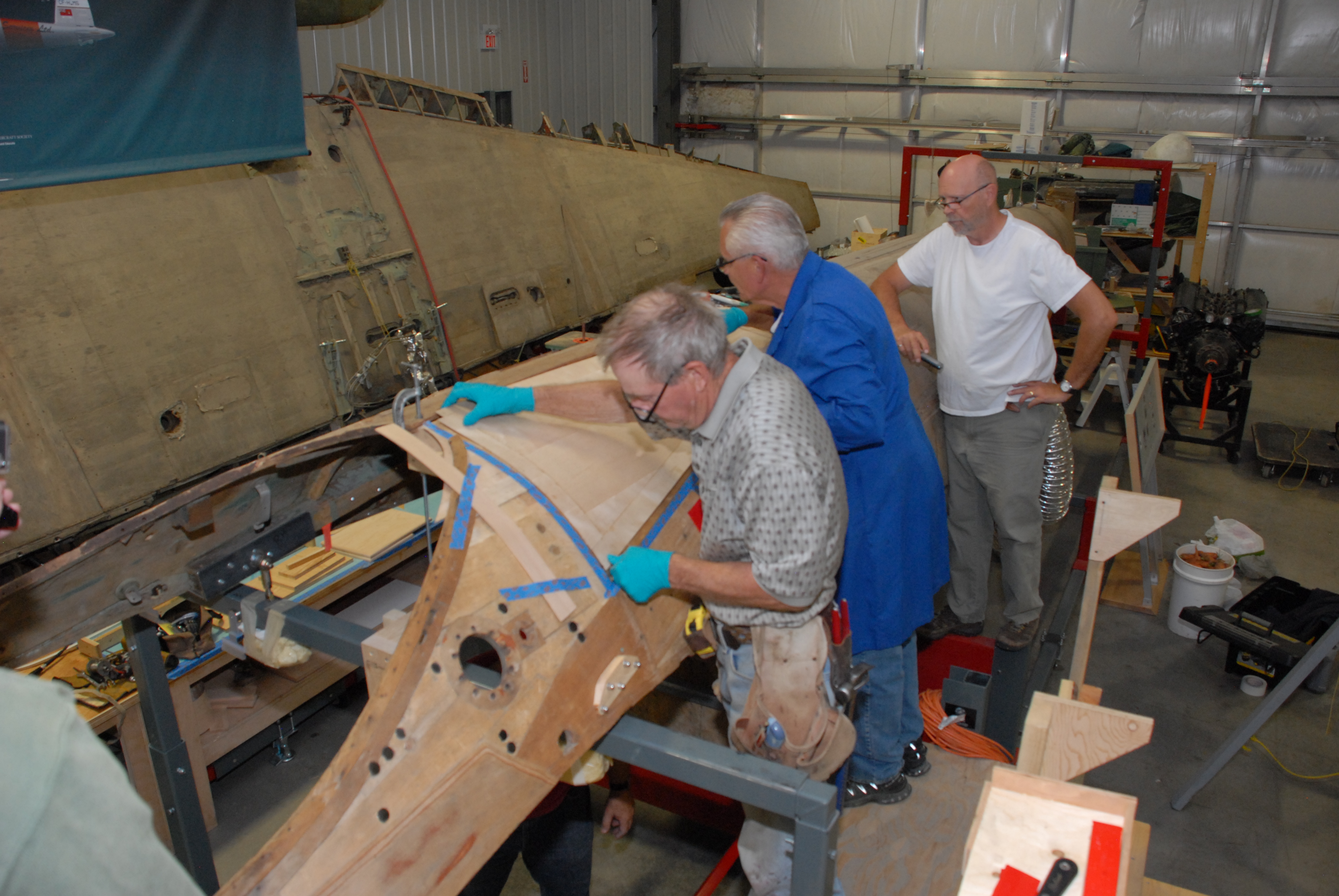 Roger and Dick (with Andy 'supervising') install the first new skin on the upper fuselage, just aft of the cockpit.