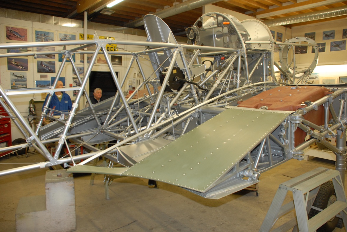 Looking as much like a steel girder bridge as an airplane, the structural heart of the Hurricane is its robust center section, seen here coming together with flap bays, upper skins and fuel tanks.